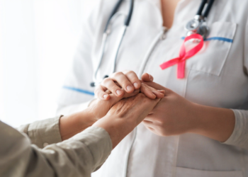 Enfermera oncológica especializada atendiendo a paciente con cáncer en hospital