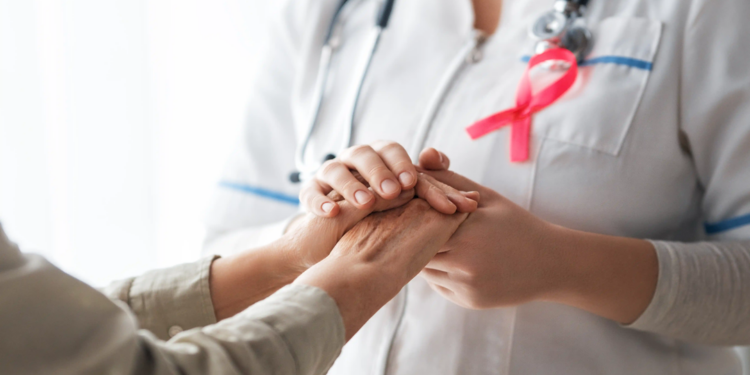 Enfermera oncológica especializada atendiendo a paciente con cáncer en hospital